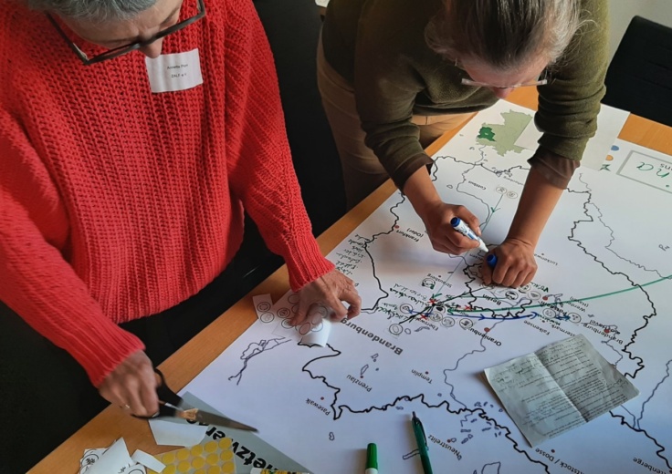 2 Projektmitarbeiterinnen bearbeiten eine Brandenburg-Karte
